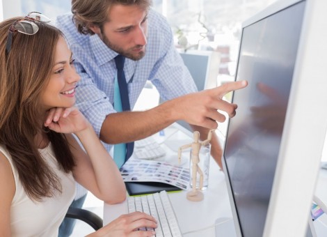 Man pointing something to his partner on screen in creative office